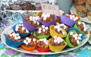 A large plate of chocolate cornflake cakes with a price tag of £1.00 on the top